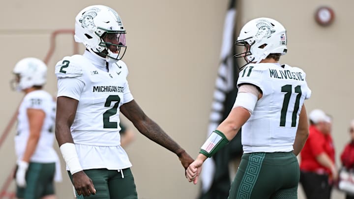 Oct 18, 2025; Bloomington, Indiana, USA; Michigan State Spartans quarterback Aidan Chiles (2) fist pumps Michigan State Spartans quarterback Alessio Milivojevic (11) prior to the game against the Indiana Hoosiers at Memorial Stadium. Mandatory Credit: Robert Goddin-Imagn Images
