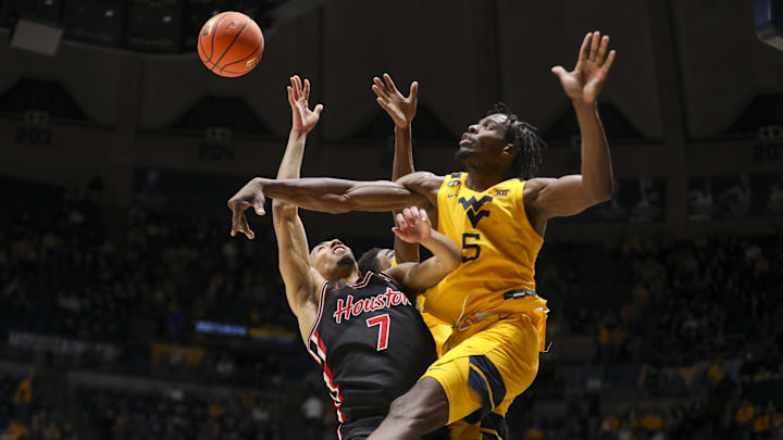 Jan 29, 2025; Morgantown, West Virginia, USA; West Virginia Mountaineers guard Toby Okani (5) blocks a shot from Houston Cougars guard Milos Uzan (7) during the second half at WVU Coliseum. Mandatory Credit: Ben Queen-Imagn Images