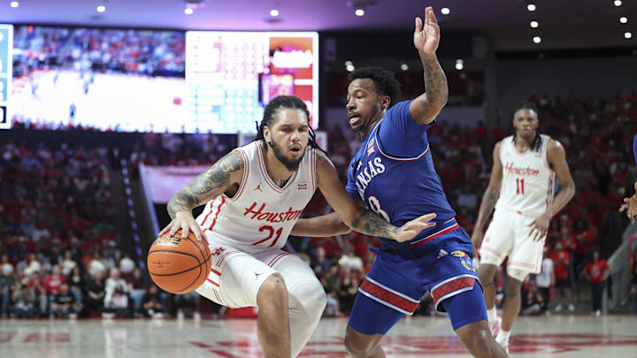 Mar 3, 2025; Houston, Texas, USA; Houston Cougars guard Emanuel Sharp (21) drives with the ball as Kansas Jayhawks guard David Coit (8) defends during the second half at Fertitta Center. Mandatory Credit: Troy Taormina-Imagn Images