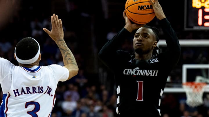 Cincinnati Bearcats guard Day Day Thomas (1) hits a 3-point basket over Kansas Jayhawks guard Dajuan Harris Jr. (3) in the second half of the Big 12 Conference tournament game between Cincinnati Bearcats and Kansas Jayhawks at T-Mobile Center in Kansas City, Mo., on Wednesday, March 13, 2024. Cincinnati Bearcats guard Day Day Thomas (1) hits a 3-point basket over Kansas Jayhawks guard Dajuan Harris Jr. (3) in the second half of the Big 12 Conference tournament game between Cincinnati Bearcats and Kansas Jayhawks at T-Mobile Center in Kansas City, Mo., on Wednesday, March 13, 2024.