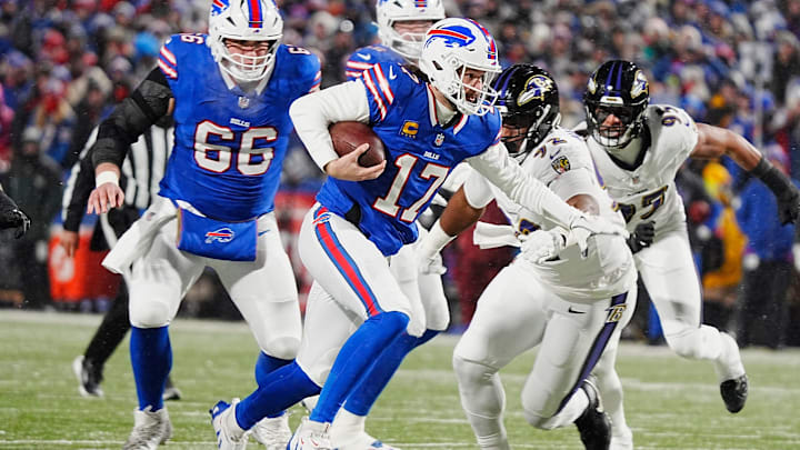 Buffalo Bills quarterback Josh Allen runs with the ball trying to avoid the reach of Baltimore Ravens defensive tackle Nnamdi Madubuike during first half action during the Buffalo Bills divisional game against the Baltimore Ravens at Highmark Stadium in Orchard Park on Jan. 19, 2025.