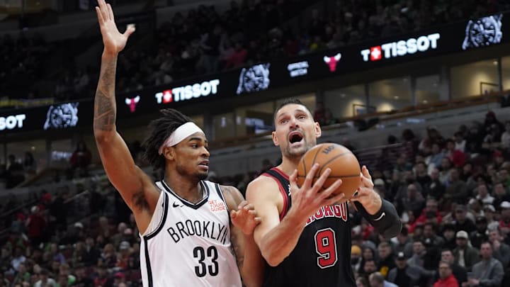 Mar 13, 2025; Chicago, Illinois, USA; Brooklyn Nets center Nic Claxton (33) defends Chicago Bulls center Nikola Vucevic (9) during the first quarter at United Center. Mandatory Credit: David Banks-Imagn Images