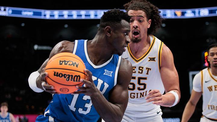 Mar 11, 2026; Kansas City, MO, USA; BYU Cougars forward Keba Keita (13) drives to the basket around West Virginia Mountaineers center Harlan Obioha (55) during the second half at T-Mobile Center. Mandatory Credit: William Purnell-Imagn Images Mar 11, 2026; Kansas City, MO, USA; BYU Cougars forward Keba Keita (13) drives to the basket around West Virginia Mountaineers center Harlan Obioha (55) during the second half at T-Mobile Center. Mandatory Credit: William Purnell-Imagn Images
