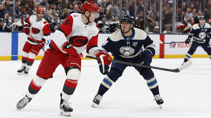 Mar 31, 2026; Columbus, Ohio, USA; Carolina Hurricanes defenseman Alexander Nikishin (21) passes the puck asColumbus Blue Jackets center Cole Sillinger (4) defends during the second period at Nationwide Arena. Mandatory Credit: Russell LaBounty-Imagn Images
