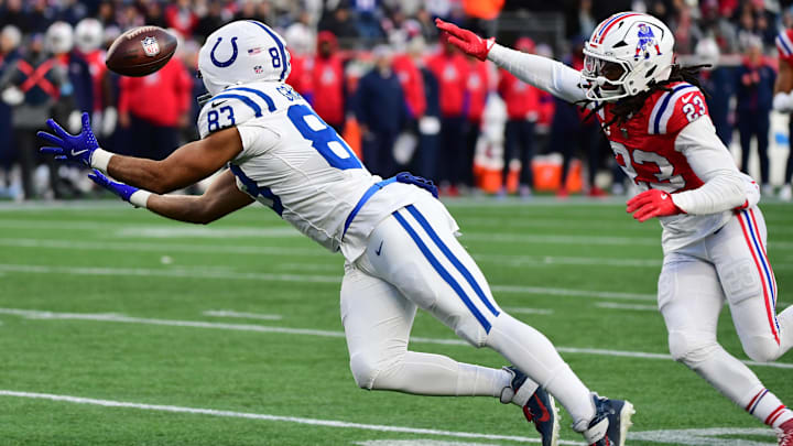 Dec 1, 2024; Foxborough, Massachusetts, USA;  Indianapolis Colts tight end Kylen Granson (83) stretches for a pass while New England Patriots safety Kyle Dugger (23) defends during the second half at Gillette Stadium. Mandatory Credit: Bob DeChiara-Imagn Images