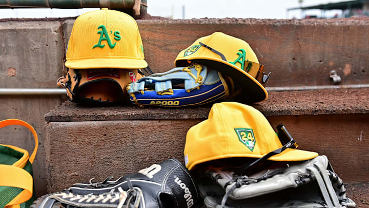 Mar 6, 2024; Tempe, Arizona, USA; General view of Oakland Athletics hats and gloves prior to a spring training game against the Los Angeles Angels at Tempe Diablo Stadium. Mandatory Credit: Matt Kartozian-Imagn Images Mar 6, 2024; Tempe, Arizona, USA; General view of Oakland Athletics hats and gloves prior to a spring training game against the Los Angeles Angels at Tempe Diablo Stadium. Mandatory Credit: Matt Kartozian-Imagn Images