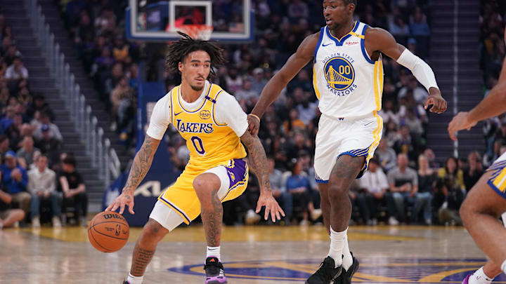 Oct 18, 2024; San Francisco, California, USA; Los Angeles Lakers guard Jalen Hood-Schifino (0) dribbles the ball next to Golden State Warriors forward Jonathan Kuminga (00) in the first quarter at the Chase Center. Mandatory Credit: Cary Edmondson-Imagn Images
