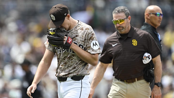 Apr 12, 2026; San Diego, California, USA; San Diego Padres starting pitcher Nick Pivetta (27), left, leaves the field with a trainer during the fourth inning against the Colorado Rockies at Petco Park. Mandatory Credit: Denis Poroy-Imagn Images