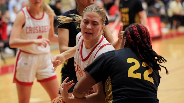 Bishop Kenny's Kathleen Crawley (22), center, is guarded by Rutherford's Jhishae Baker (22) during the first quarter of a FHSAA Region 1-4A girls basketball final Thursday, Feb. 22, 2024 at Bishop Kenny High School in Jacksonville, Fla. The Bishop Kenny Crusaders held off the Rutherford Rams 53-39. [Corey Perrine/Florida Times-Union]
