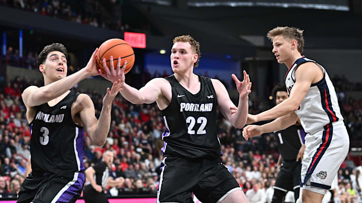 Jan 2, 2025; Spokane, Washington, USA; Portland Pilots forward Austin Rapp (22) rebounds against Gonzaga Bulldogs forward Ben Gregg (33) in the first half at Spokane Veterans Memorial Arena. Mandatory Credit: James Snook-Imagn Images