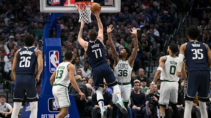 Jan 5, 2023; Dallas, Texas, USA; Dallas Mavericks guard Luka Doncic (77) makes a jump shot over Boston Celtics guard Malcolm Brogdon (13) and guard Marcus Smart (36) and forward Jayson Tatum (0) during the second quarter at the American Airlines Center. Mandatory Credit: Jerome Miron-Imagn Images