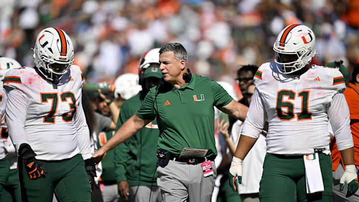 Nov 1, 2025; Dallas, Texas, USA;  Miami Hurricanes head coach Mario Cristobal talks to offensive lineman Anez Cooper (73) and offensive lineman Francis Mauigoa (61) during the second half against the SMU Mustangs at Gerald J. Ford Stadium. Mandatory Credit: Jerome Miron-Imagn Images