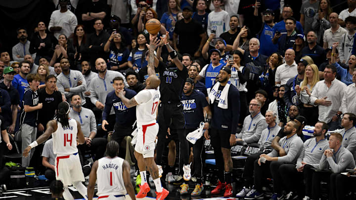 Dallas Mavericks guard Kyrie Irving (11) makes a three point shot and is fouled by LA Clippers forward P.J. Tucker (17) during the 2024 NBA playoffs at American Airlines Center. 