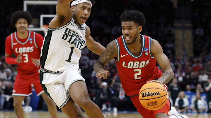 Mar 23, 2025; Cleveland, OH, USA; New Mexico Lobos guard Donovan Dent (2) dribbles the ball defended by Michigan State Spartans guard Jeremy Fears Jr. (1) in the second half during the NCAA Tournament Second Round at Rocket Arena. Mandatory Credit: Rick Osentoski-Imagn Images