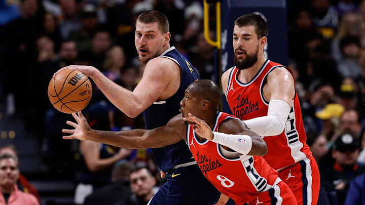 Dec 13, 2024; Denver, Colorado, USA; Los Angeles Clippers guard Kris Dunn (8) attempts to steal the ball away from Denver Nuggets center Nikola Jokic (15) as center Ivica Zubac (40) defends in the second quarter at Ball Arena. Mandatory Credit: Isaiah J. Downing-Imagn Images