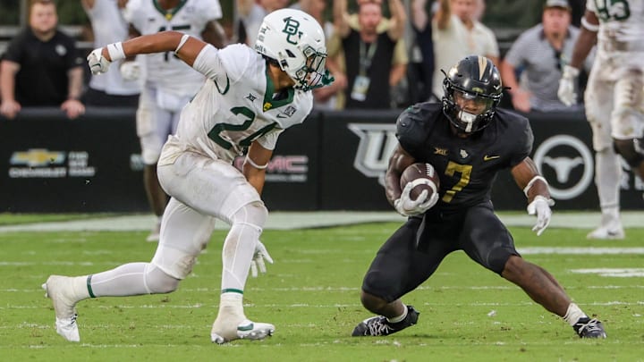 Sep 30, 2023; Orlando, Florida, USA; UCF Knights running back RJ Harvey (7) runs the ball against Baylor Bears safety Corey Gordon Jr. (24) during the second half at FBC Mortgage Stadium.