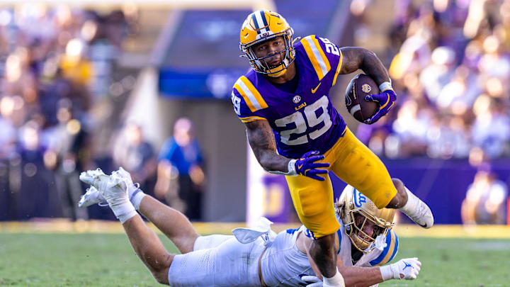 Sep 21, 2024; Baton Rouge, Louisiana, USA; UCLA Bruins linebacker Carson Schwesinger (49) misses a tackle against LSU Tigers running back Caden Durham (29) during the second half at Tiger Stadium. Mandatory Credit: Stephen Lew-Imagn Images Sep 21, 2024; Baton Rouge, Louisiana, USA; UCLA Bruins linebacker Carson Schwesinger (49) misses a tackle against LSU Tigers running back Caden Durham (29) during the second half at Tiger Stadium. Mandatory Credit: Stephen Lew-Imagn Images