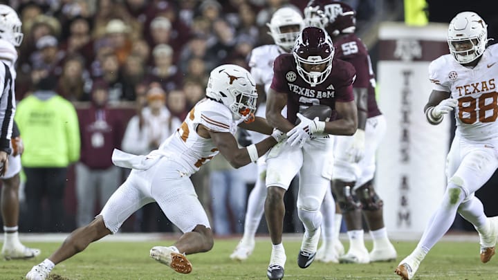 Nov 30, 2024; College Station, Texas, USA; Texas A&M Aggies wide receiver Terry Bussey (2) runs with the ball as Texas Longhorns linebacker Ty'Anthony Smith (26) attempts to make a tackle during the fourth quarter at Kyle Field. Mandatory Credit: Troy Taormina-Imagn Images