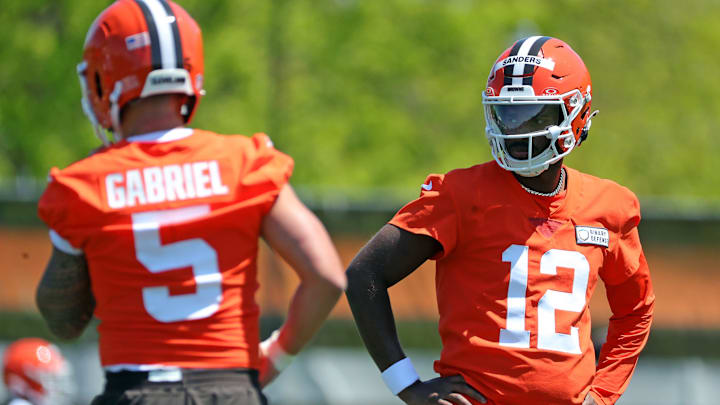 Cleveland Browns quarterback Shedeur Sanders (12) watches quarterback Dillon Gabriel (5) during day two of NFL rookie minicamp at the Cleveland Browns training facility on Saturday, May 10, 2025, in Berea, Ohio. Cleveland Browns quarterback Shedeur Sanders (12) watches quarterback Dillon Gabriel (5) during day two of NFL rookie minicamp at the Cleveland Browns training facility on Saturday, May 10, 2025, in Berea, Ohio.