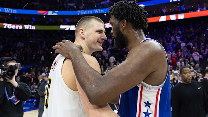 Jan 16, 2024; Philadelphia, Pennsylvania, USA; Philadelphia 76ers center Joel Embiid (21) hugs and talks with Denver Nuggets center Nikola Jokic (15) after the game at Wells Fargo Center. Mandatory Credit: Bill Streicher-Imagn Images