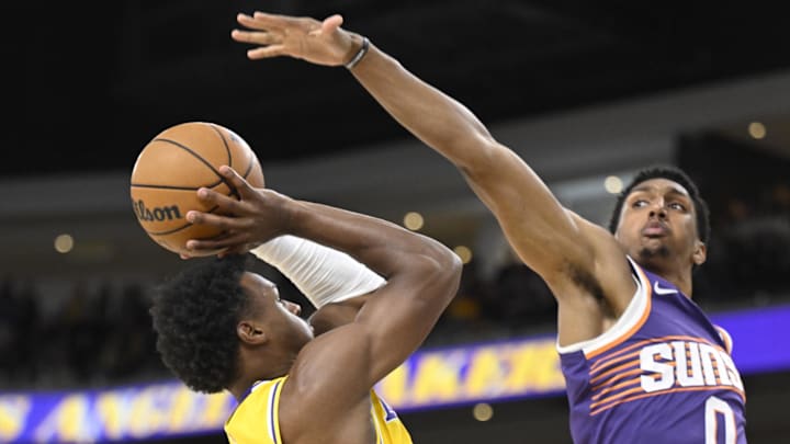 Oct 3, 2025; Palm Desert, California, USA; Los Angeles Lakers guard Bronny James (9) tries to shoot past Phoenix Suns forward Ryan Dunn (0) during the first half at Acrisure Arena. Mandatory Credit: Denis Poroy-Imagn Images