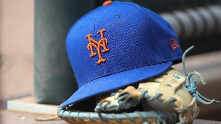 Jul 13, 2022; Atlanta, Georgia, USA; A detailed view of a New York Mets hat and glove in the dugout against the Atlanta Braves in the eighth inning at Truist Park. Mandatory Credit: Brett Davis-Imagn Images