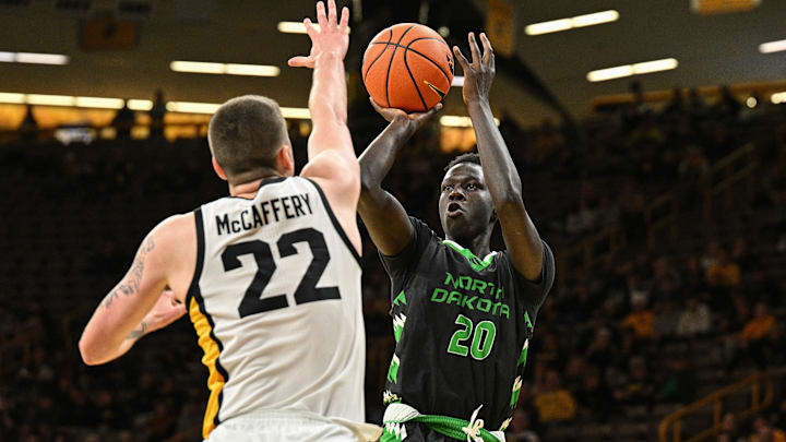 Nov 7, 2023; Iowa City, Iowa, USA; North Dakota Fighting Hawks forward B.J. Omot (20) shoots against Iowa Hawkeyes forward Patrick McCaffery (22) during the first half at Carver-Hawkeye Arena. Mandatory Credit: Jeffrey Becker-Imagn Images
