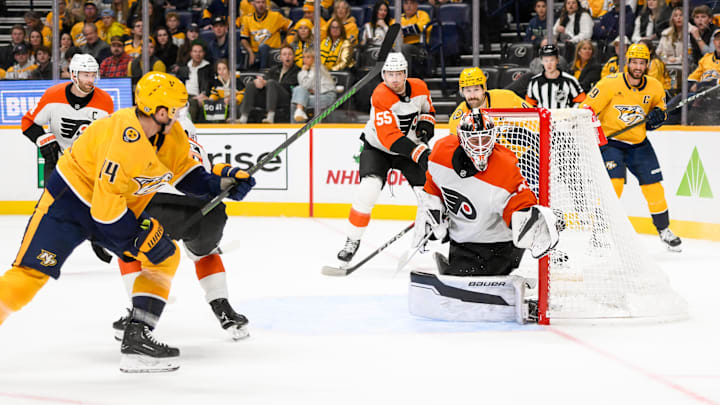 Nov 27, 2024; Nashville, Tennessee, USA;  Philadelphia Flyers goaltender Aleksei Kolosov (35) blocks the shot of Nashville Predators center Gustav Nyquist (14) during the first period at Bridgestone Arena. Mandatory Credit: Steve Roberts-Imagn Images