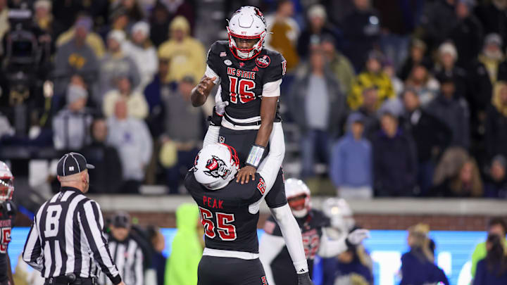 Nov 21, 2024; Atlanta, Georgia, USA; North Carolina State Wolfpack quarterback CJ Bailey (16) celebrates after scoring a two-point conversion with offensive tackle Jacarrius Peak (65) against the Georgia Tech Yellow Jackets in the fourth quarter at Bobby Dodd Stadium at Hyundai Field. Mandatory Credit: Brett Davis-Imagn Images Nov 21, 2024; Atlanta, Georgia, USA; North Carolina State Wolfpack quarterback CJ Bailey (16) celebrates after scoring a two-point conversion with offensive tackle Jacarrius Peak (65) against the Georgia Tech Yellow Jackets in the fourth quarter at Bobby Dodd Stadium at Hyundai Field. Mandatory Credit: Brett Davis-Imagn Images
