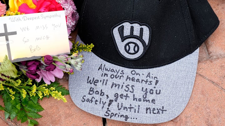 A baseball cap with a message sets at a memorial at the base of a Bob Uecker statue outside American Family Field in Milwaukee on Thursday, Jan. 16, 2025. Uecker, the voice of the team on the airwaves for 54 years, a Baseball Hall of Famer and local, statewide and national icon, died Thursday.