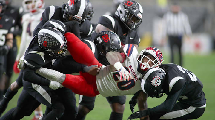 McKeesport's Kemon Spell (20) gets taken to the ground by multiple Aliquippa defenders during the second half of the WPIAL 4A Championship game Friday evening at Acrisure Stadium in Pittsburgh, PA.