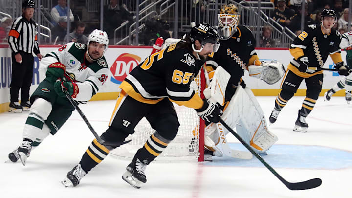 Oct 29, 2024; Pittsburgh, Pennsylvania, USA; Pittsburgh Penguins defenseman Erik Karlsson (65) skates with the puck as Minnesota Wild right wing Mats Zuccarello (36) chases during the second period at PPG Paints Arena. Mandatory Credit: Charles LeClaire-Imagn Images
