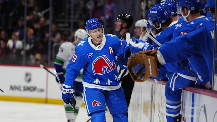 Apr 1, 2026; Denver, Colorado, USA; Colorado Avalanche center Nathan MacKinnon (29) (center) celebrates his fiftieth goal of the season with teammates during the first period against the Vancouver Canucks at Ball Arena. Mandatory Credit: Ron Chenoy-Imagn Images