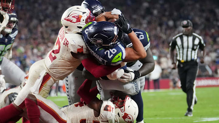 Seattle Seahawks running back Zach Charbonnet (26) breaks into the end zone for a touchdown through Arizona Cardinals safety Jalen Thompson (34) and linebacker Mack Wilson Sr. (2) at State Farm Stadium in Glendale on Sept. 25, 2025. Seattle Seahawks running back Zach Charbonnet (26) breaks into the end zone for a touchdown through Arizona Cardinals safety Jalen Thompson (34) and linebacker Mack Wilson Sr. (2) at State Farm Stadium in Glendale on Sept. 25, 2025.
