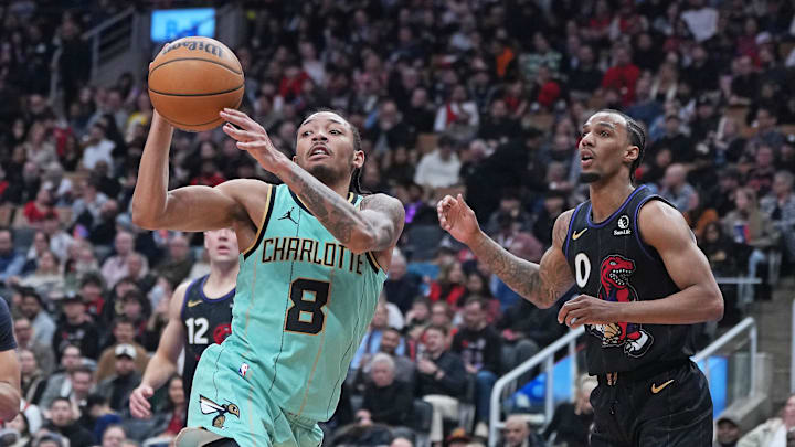 Apr 9, 2025; Toronto, Ontario, CAN; Charlotte Hornets guard Nick Smith Jr. (8) passes against Toronto Raptors guard A.J. Lawson (0) during the third quarter at Scotiabank Arena. Mandatory Credit: Nick Turchiaro-Imagn Images