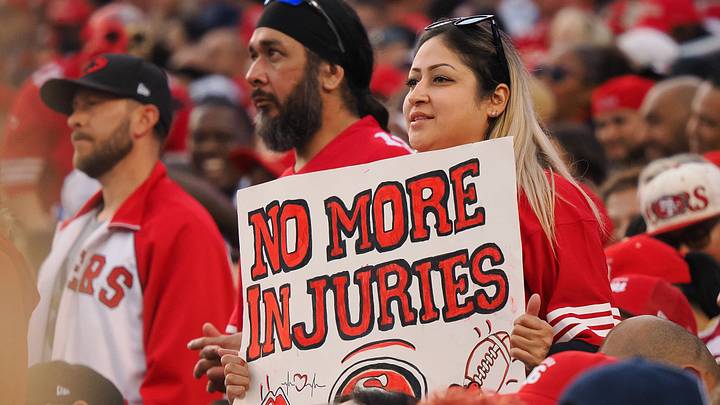 San Francisco 49ers fan holds a sign reading “no more injuries”