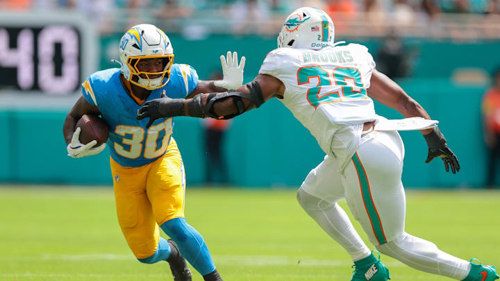 Los Angeles Chargers running back Kimani Vidal (30) carries the football against Miami Dolphins linebacker Jordyn Brooks (20) during the first quarter at Hard Rock Stadium. 