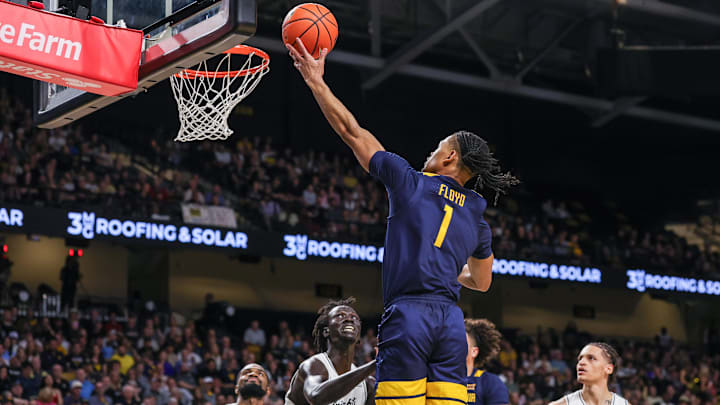 Feb 14, 2026; Orlando, Florida, USA; West Virginia Mountaineers guard Jasper Floyd (1) goes to the basket against UCF Knights center John Bol (7) during the first half at Addition Financial Arena. Mandatory Credit: Mike Watters-Imagn Images