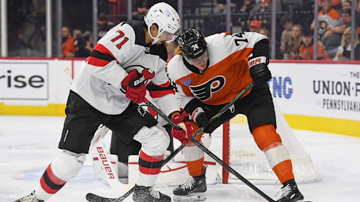 Jan 27, 2025; Philadelphia, Pennsylvania, USA; New Jersey Devils defenseman Jonas Siegenthaler (71) and Philadelphia Flyers right wing Owen Tippett (74) battle for the puck during the first period at Wells Fargo Center. Mandatory Credit: Eric Hartline-Imagn Images