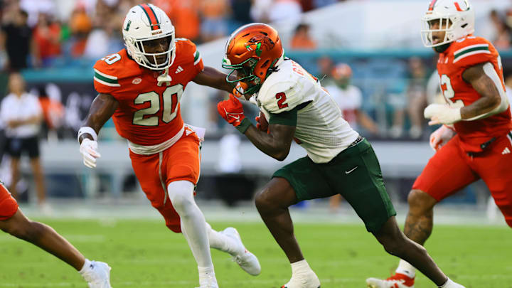 Sep 7, 2024; Miami Gardens, Florida, USA; Florida A&M Rattlers wide receiver Jamari Gassett (2) runs with the football against Miami Hurricanes defensive back Zaquan Patterson (20) during the second quarter at Hard Rock Stadium. Mandatory Credit: Sam Navarro-Imagn Images