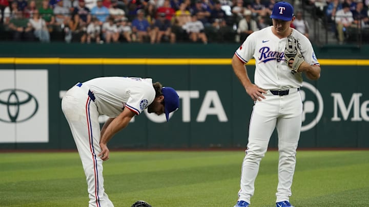 Mar 29, 2025; Arlington, Texas, USA; Texas Rangers third baseman Josh Smith (8) bends over after colliding with the railing down the left field line chasing a foul ball during the first inning against the Boston Red Sox at Globe Life Field. 
