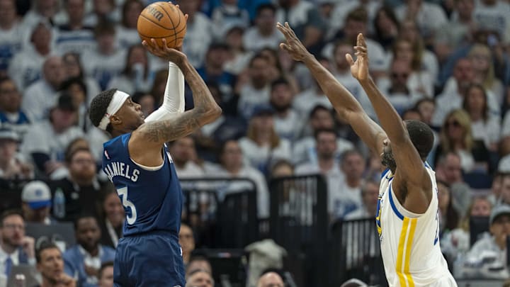 May 8, 2025; Minneapolis, Minnesota, USA; Minnesota Timberwolves forward Jaden McDaniels (3) shoots the ball over Golden State Warriors forward Draymond Green (23) in the second half during game two of the second round for the 2025 NBA Playoffs at Target Center.