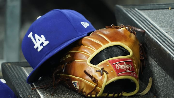 Apr 28, 2024; Toronto, Ontario, CAN; A hat and glove of an Los Angeles Dodgers player durng a game against the Toronto Blue Jays at Rogers Centre. Mandatory Credit: John E. Sokolowski-Imagn Images