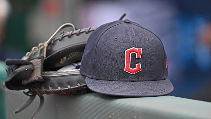 Jun 27, 2024; Kansas City, Missouri, USA; A general view a Cleveland Guardians hat and glove on the dugout railing  before a game against the Kansas City Royals at Kauffman Stadium. Mandatory Credit: Peter Aiken-Imagn Images