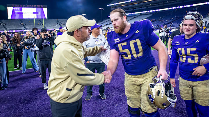 Jedd Fisch and tackle Carver Willis shake hands after the Purdue game, with kicker Grady Gross nearby. 