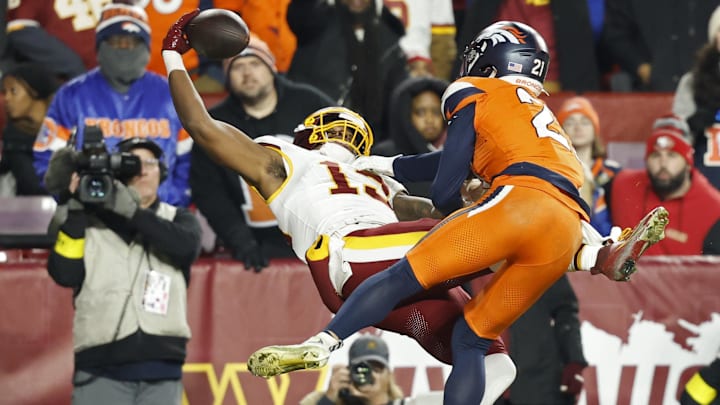 Washington Commanders wide receiver Treylon Burks (13) catches a touchdown pass as Denver Broncos cornerback Riley Moss  (21) defends in the third quarter at Northwest Stadium. 