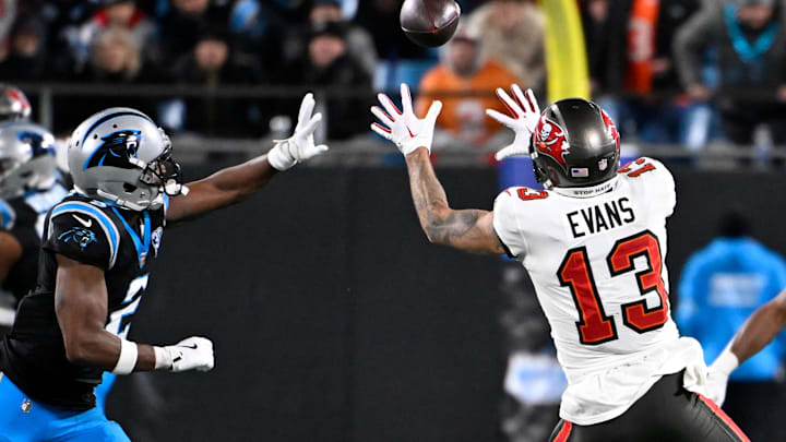Dec 1, 2024; Charlotte, North Carolina, USA;  Tampa Bay Buccaneers wide receiver Mike Evans (13) catches the ball as Carolina Panthers cornerback Michael Jackson (2) defends in overtime at Bank of America Stadium. Mandatory Credit: Bob Donnan-Imagn Images