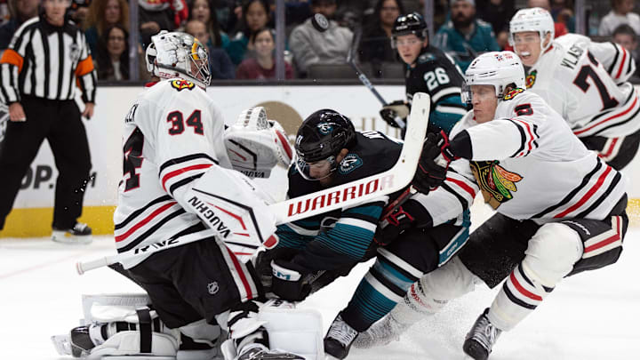 Oct 31, 2024; San Jose, California, USA; San Jose Sharks center Luke Kunin (11) collides with Chicago Blackhawks goaltender Petr Mrazek (34) during the second period at SAP Center at San Jose. Mandatory Credit: D. Ross Cameron-Imagn Images