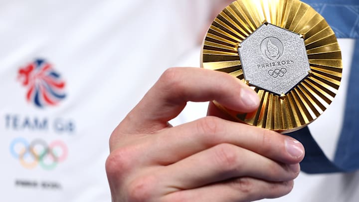 An athlete holds up a gold medal at the 2024 Paris Games.