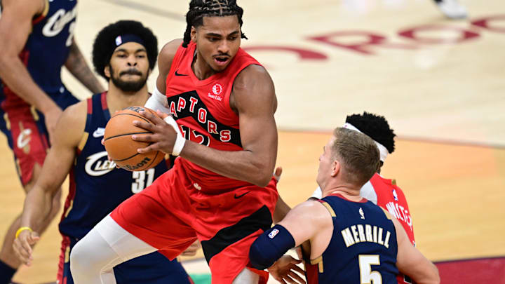 Apr 20, 2026; Cleveland, Ohio, USA; Toronto Raptors forward Collin Murray-Boyles (12) grabs a rebound against Cleveland Cavaliers guard Sam Merrill (5) during the second half during game two of the first round of the 2026 NBA Playoffs at Rocket Arena. Mandatory Credit: David Dermer-Imagn Images
